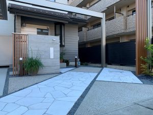 重厚感あるカーポートと石の家